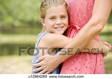 Stock Photo - girl hugging woman around the waist. Fotosearch