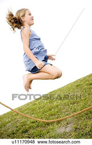 Stock Photo - girl jumping high in air over skipping rope. Fotosearch
