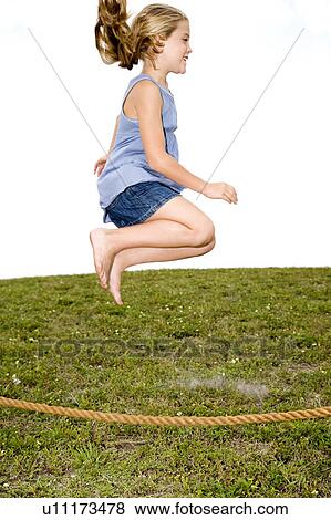 Stock Photo - girl jumping high in air over skipping rope. Fotosearch