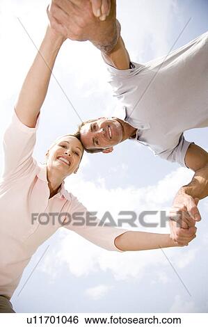 Stock Photograph - low angle shot couple holding hands having fun. Fotosearch