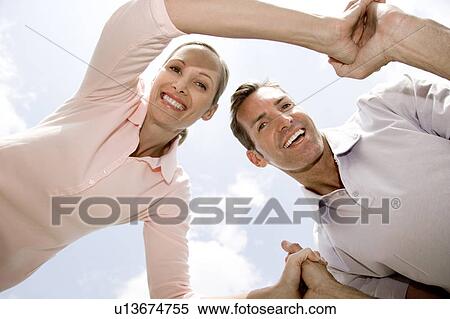 low angle shot couple holding hands having fun View Large Photo Image Stock Photography - low angle shot couple holding hands having fun. Fotosearch
