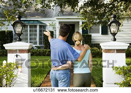 Couple standing on the garden path outside their new home View Large Photo Image Stock Image - Couple standing on the garden path outside their new home. Fotosearch