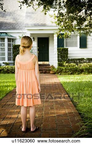 Little girl standing on the garden path outside her new home View Large Photo Image Stock Image - Little girl standing on the garden path outside her new home. Fotosearch