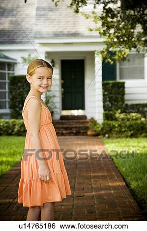 Little girl standing on the garden path outside her new home View Large Photo Image Stock Photograph - Little girl standing on the garden path outside her new home. Fotosearch