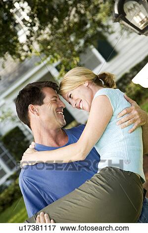 Man carrying his wife across the threshold of their new home View Large Photo Image Stock Photo - Man carrying his wife across the threshold of their new home. Fotosearch