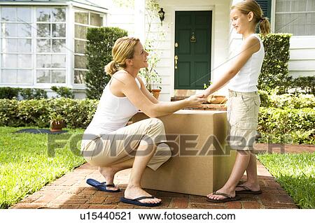 Mother and daughter moving into their new home View Large Photo Image Stock Image - Mother and daughter moving into their new home. Fotosearch