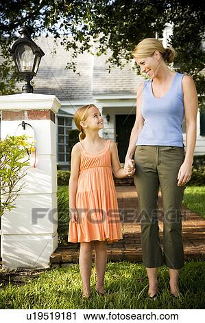 Mother and daughter standing on the garden path outside their new home View Large Photo Image Stock Image - Mother and daughter standing on the garden path outside their new home. Fotosearch