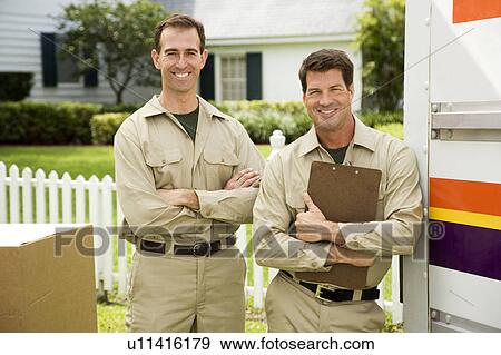 Stock Photo - Removal men standing beside their van with packing boxes. Fotosearch