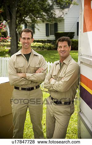 Stock Photo - Removal men standing beside their van with packing boxes. Fotosearch
