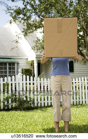 Woman carrying a large packing box View Large Photo Image Stock Image - Woman carrying a large packing box. Fotosearch