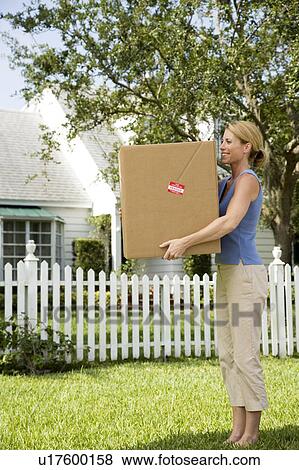 Woman moving house, carrying large packing box View Large Photo Image Stock Photo - Woman moving house, carrying large packing box. Fotosearch