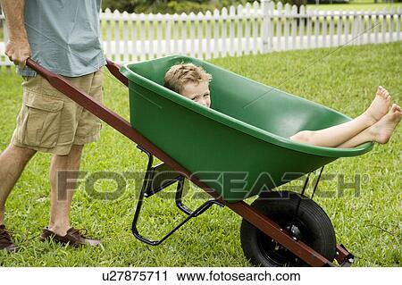 boy having a ride in a wheelbarrow View Large Photo Image Stock Image - boy having a ride in a wheelbarrow. Fotosearch
