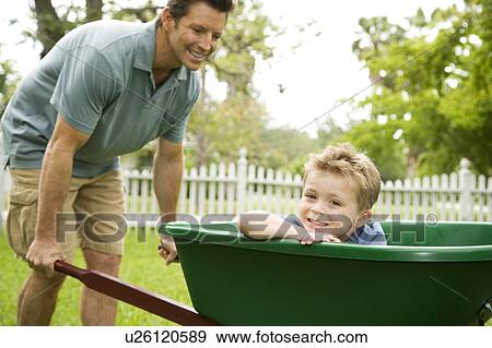 Stock Photo - father giving son ride in the wheelbarrow. Fotosearch