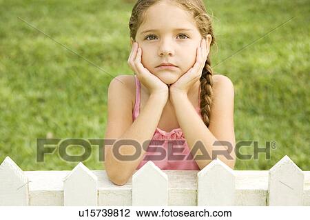 little girl leaning on fence looking sad View Large Photo Image Stock Image - little girl leaning on fence looking sad. Fotosearch