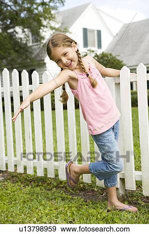little girl posing standing by picket fence View Large Photo Image Stock Photo - little girl posing standing by picket fence. Fotosearch