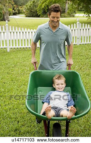 man giving boy a ride in the wheelbarrow View Large Photo Image Stock Image - man giving boy a ride in the wheelbarrow. Fotosearch