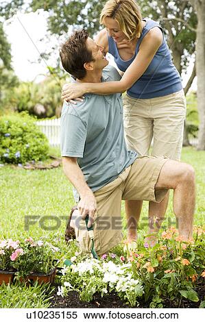 woman embracing gardening husband View Large Photo Image Stock Photography - woman embracing gardening husband. Fotosearch