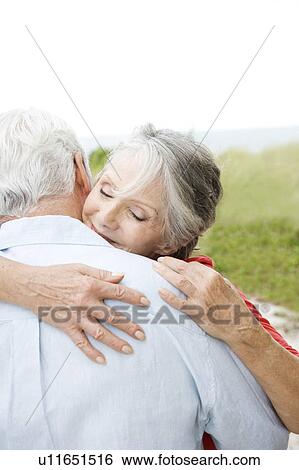 Stock Photograph - Senior couple embracing at the beach . Fotosearch