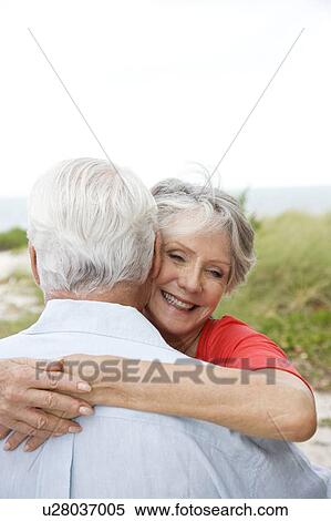 Stock Photography - Senior couple embracing at the beach . Fotosearch