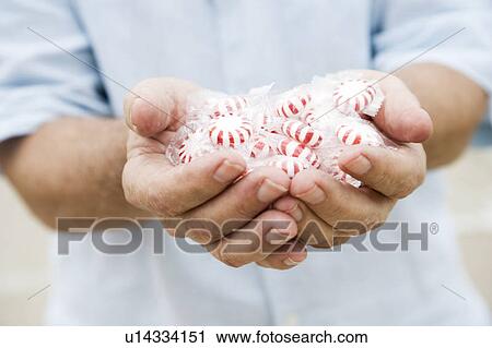 Senior man's hand holding sweets or candy View Large Photo Image Stock Image - Senior man's hand holding sweets or candy. Fotosearch
