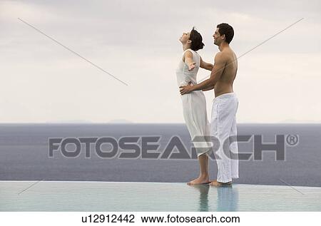 A couple balancing at the edge of a pool View Large Photo Image Stock Image - A couple balancing at the edge of a pool. Fotosearch