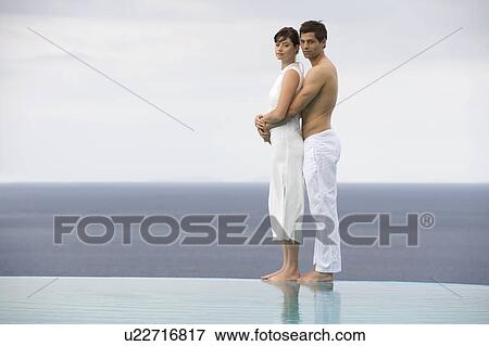 Stock Photo - A couple embracing by a pool. Fotosearch