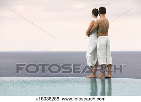 Stock Photography - A couple embracing by a pool. Fotosearch