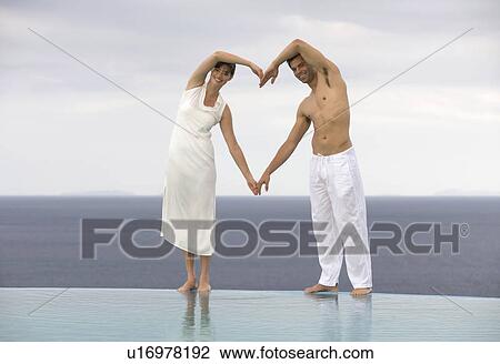 A couple forming the shape of a heart View Large Photo Image Stock Image - A couple forming the shape of a heart. Fotosearch