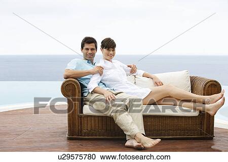 Stock Image - A couple relaxing on a sofa. Fotosearch
