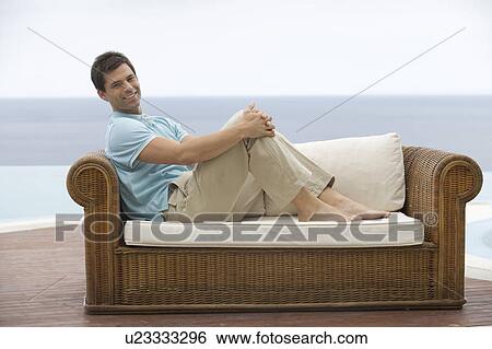Stock Photograph - A man relaxing on a sofa. Fotosearch