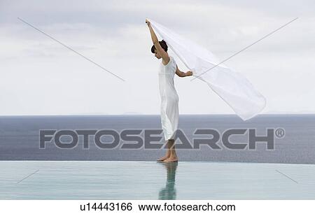 Stock Photograph - A woman relaxing by a pool. Fotosearch