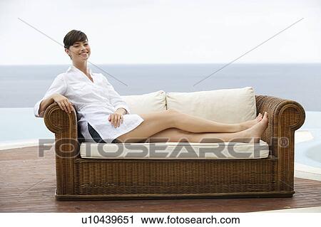 Stock Image - A woman relaxing on a sofa. Fotosearch