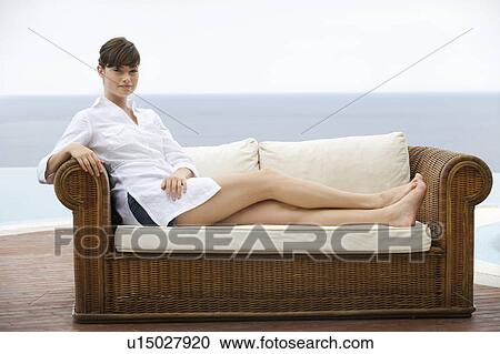 Stock Image - A woman relaxing on a sofa. Fotosearch