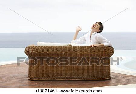 A woman relaxing on a sofa View Large Photo Image Stock Image - A woman relaxing on a sofa. Fotosearch