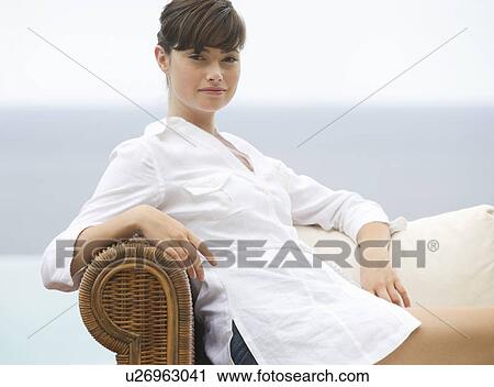 A woman relaxing on a sofa View Large Photo Image Stock Image - A woman relaxing on a sofa. Fotosearch