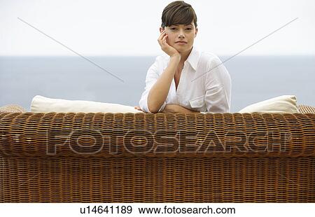 Stock Photo - A woman relaxing on a sofa. Fotosearch