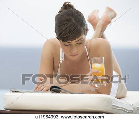 A woman relaxing on a sun lounger View Large Photo Image Stock Image - A woman relaxing on a sun lounger. Fotosearch