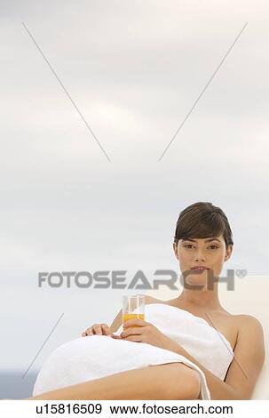 Stock Photo - A woman relaxing on a sun lounger. Fotosearch