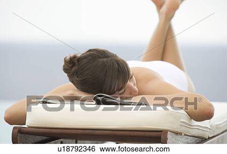 A woman relaxing on a sun lounger View Large Photo Image Stock Photograph - A woman relaxing on a sun lounger. Fotosearch