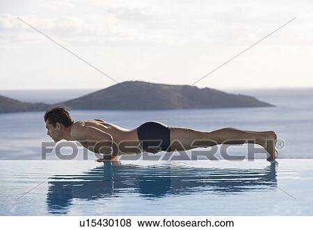 Stock Photo - A man exercising by a pool. Fotosearch