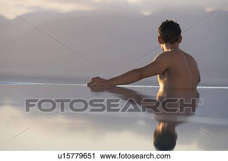 Stock Image - A man relaxing in a pool. Fotosearch