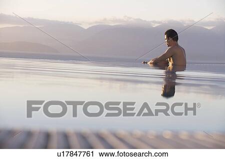 Stock Image - A man relaxing in a pool. Fotosearch