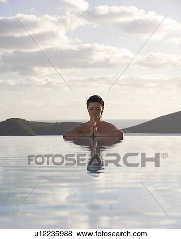 Stock Photo - A woman meditating in a pool. Fotosearch