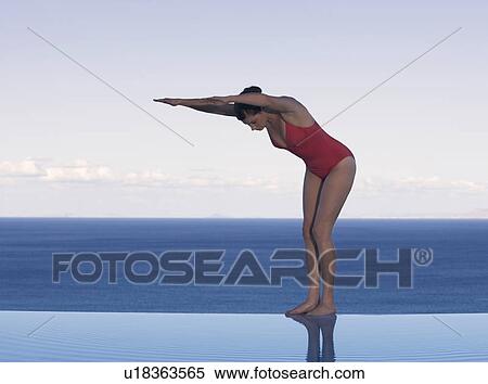 Stock Photography - A woman preparing to dive into a pool. Fotosearch