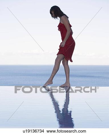 A woman standing on the edge of a pool View Large Photo Image Picture - A woman standing on the edge of a pool. Fotosearch