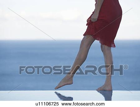 A woman standing on the edge of a pool View Large Photo Image Stock Photography - A woman standing on the edge of a pool. Fotosearch