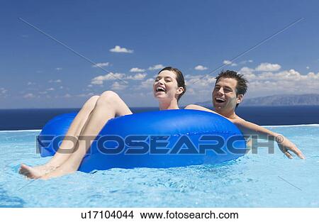 Picture - A couple relaxing in a pool. Fotosearch