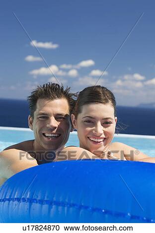 Stock Image - A couple relaxing in a pool. Fotosearch
