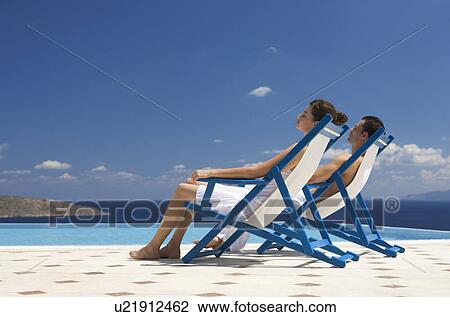 A couple relaxing in deck chairs View Large Photo Image Stock Image - A couple relaxing in deck chairs. Fotosearch