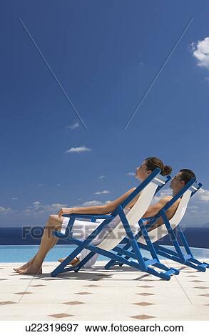 Stock Photo - A couple relaxing in deck chairs. Fotosearch